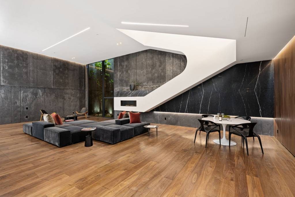 Luxury black marble feature wall with sculptural staircase and wooden flooring